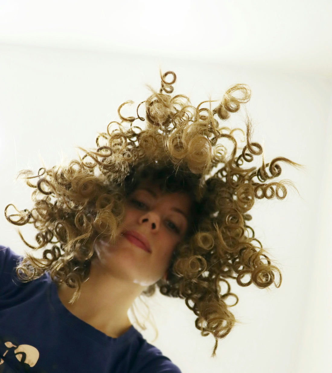 femme avec cheveux bouclés regarde vers le bas